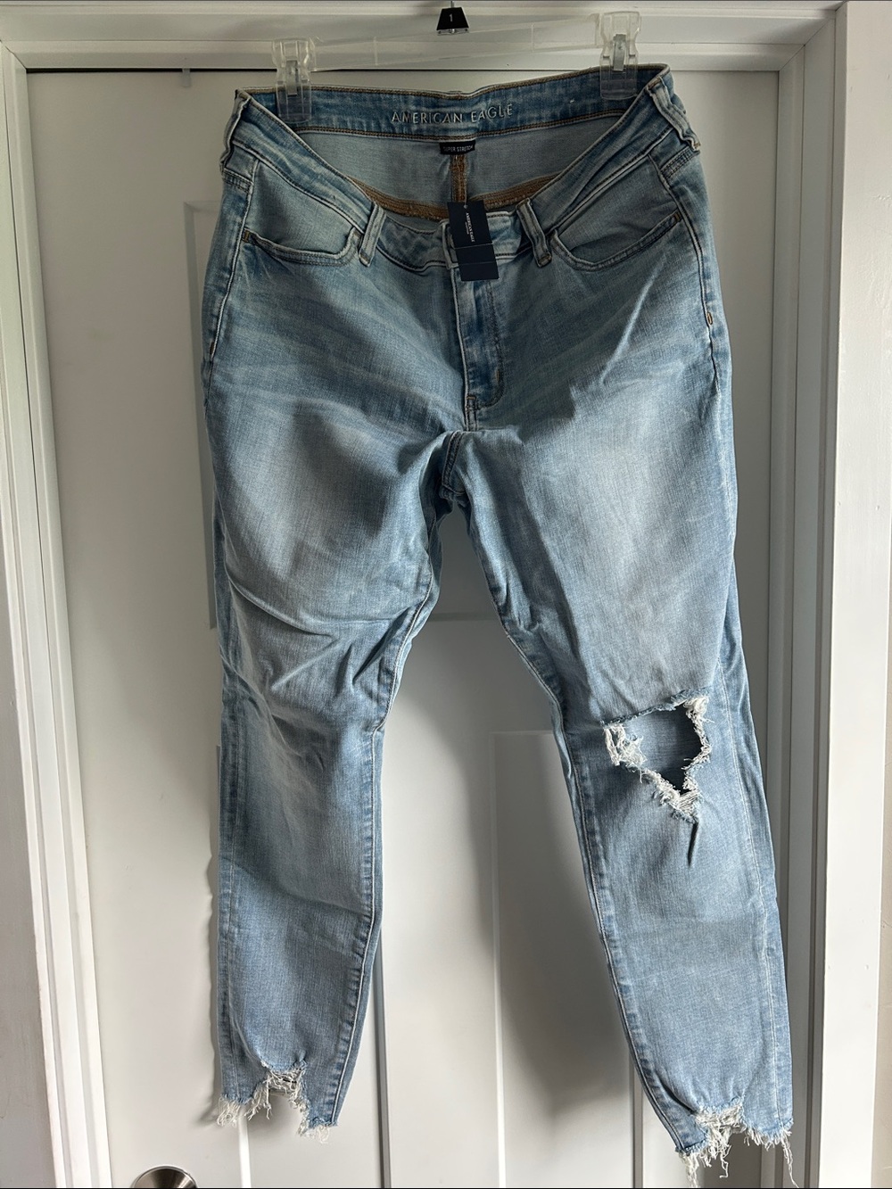 NWT, American Eagle super stretch, light wash distressed, frayed jeans, size 16